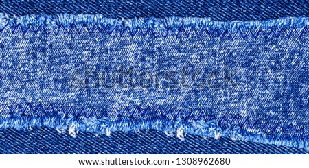 Denim frame. Ripped denim fabric with fringe edge on bleached denim background, text place, copy space. Denim jeans cloth texture, recycling concept 