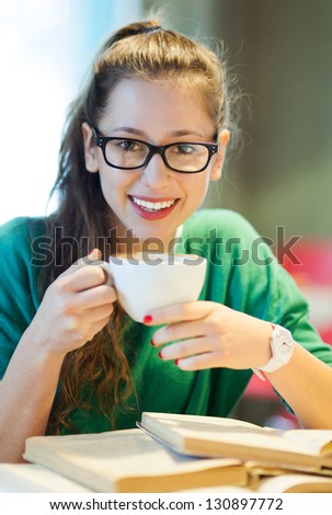 Female student with books and cup of coffee