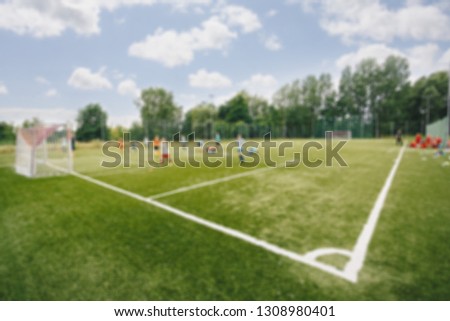 Blurred picture of soccer field at school on summer day time. Background image of blurred football pitch. Image for background usage