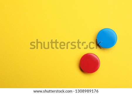 Bright magnets on color background, top view with space for text