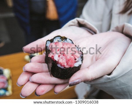 Close-up of salmon sushi on hands. Japanese traditional food.