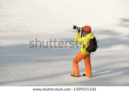 
photographer with a large lens is on the ski slope