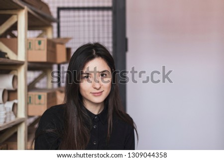 young pretty girl, student, hipster, doing a startup, working in an office or library, browsing dusty shelves with cardboard boxes in typography