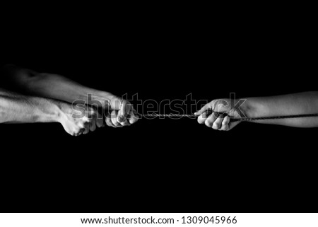 Tug war, man and woman pulling rope in opposite directions unequally, uneven. copy space Royalty-Free Stock Photo #1309045966