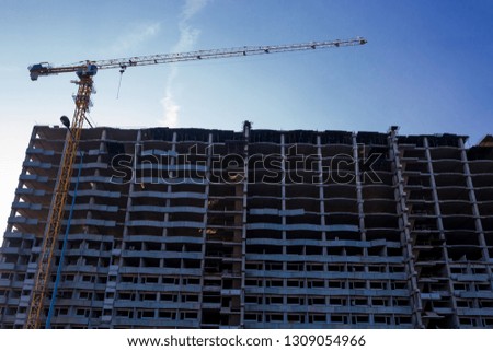 Building crane and buildings under construction. the construction crane and the building against the blue sky