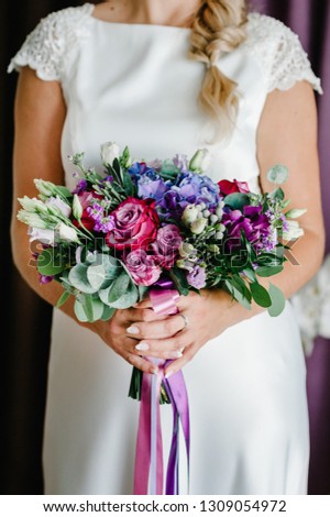 Bride showing off her beautiful  bouquet of pink, violet, purple flowers. Perfect image with copy space for chic wedding magazines and websites, bohemian, fashion style, florist.