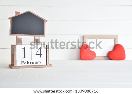 Valentines day concept, Happy Valentines Day, Valentines background. February 14 text wooden block calendar with picture frame and two red hearts on white wooden background.
