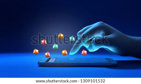 Female hand touching screen of the phone surrounded with social media notification icons