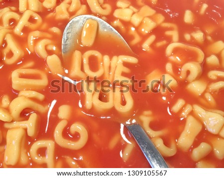 Alphabet shape pasta in tomato sauce written with wordS I love you on a spoon. Can be used for valentine’s day