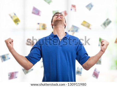 Happy young man in the middle of a rain of money