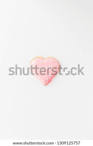 Heart shape cookie with love sign on white textured background. Valentines day minimalism concept copy space for text