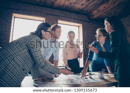 Close up photo stand focused around table business people she her he him his show documents papers explain talk tell development finance investment dressed formal wear jackets shirts spectacles specs