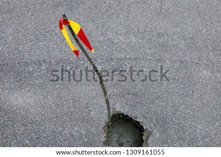 Failure in the asphalt marked with a pushpin with the restrictive red-and-yellow ribbon as an operational measure for motorists, washed out road