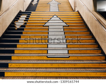 Big arrows direction symbol on concrete stair in subway in Japan. there is separate the walk way clearly. Line up and down.