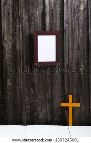 empty picture frame, cross, old weathered wooden wall background
