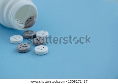 Pills medical. With painted faces and no pictures. Pills of joy, sadness,dead and indifference on blue background close-up