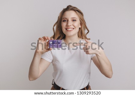 Smiling woman holding credit card. isolated portrait.