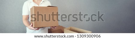 panoramic image of unknown man holding cardboard boxex in his hand, copy space