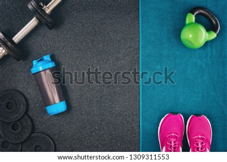 Fitness or bodybuilding concept background. Product photograph of old iron dumbbells on black grey, conrete floor in the gym. Photograph taken from above, top view with lots of copy space