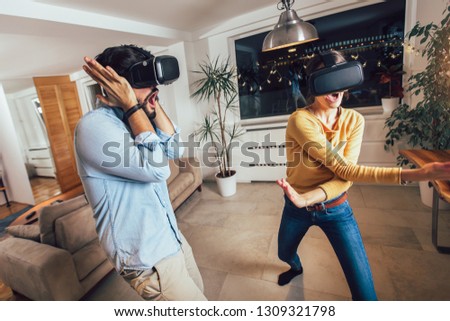 Young couple having fun with virtual reality headset glasses - Happy people playing game with new trends technology 