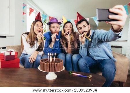 Young group of happy friends celebrating birthday at home make selfie photo.