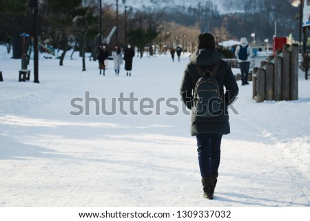 Travel woman or photographer with backpack against snow in winter season at Toya city, Hokkaido, Japan