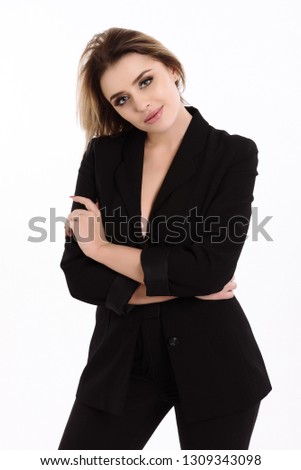 
A girl with beautiful eyes and lips in pants and a jacket beautifully poses on a white background.