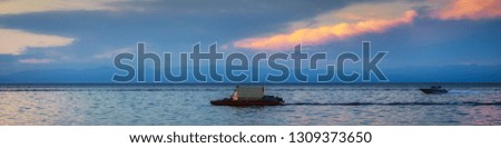 Summer panoramic landscape with view of floating raft on lake Baikal in evening at sunset. Banner for active leisure, adventure, wanderlust themes