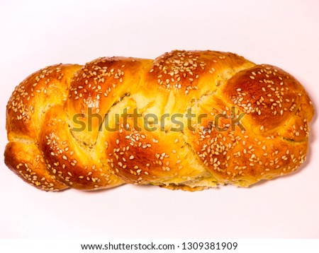 Bright fresh golden diagonal challah bread for Shabbat. Sesame seeds. isolated on white. Warm, cross wheat bread. Shabbat Shalom baking concept. Kosher food background. Jewish holiday cooking concept.