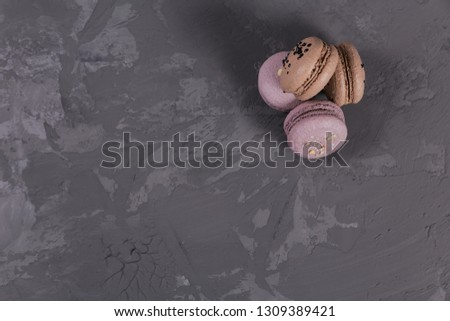Heap of sweet french macarons on grey concrete background. Pastel colored macaroons cookies. Food, culinary, bakery and cooking concept