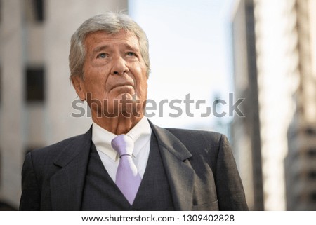 Senior businessman in city serious angry face portrait