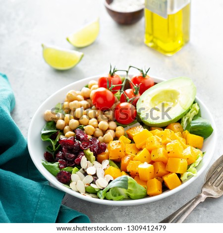 Vegan lunch bowl with chickpeas, avocado, vegetables, and roasted squash