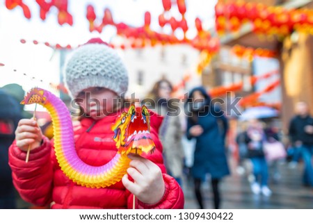 Girl holding chinese dragon at new year celebrations, London