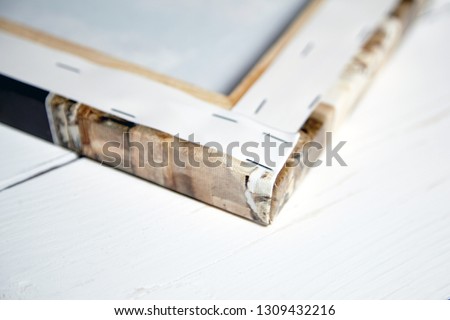 Gallery wrap, photo printed on glossy synthetic canvas and stretched on wooden stretcher bar, back and side view, closeup, selective focus