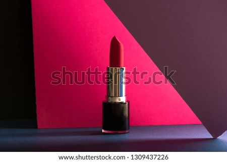 Elegant make-up stills, pink lipstick on colorful geometric background. Product and make up contemporanean concept. front view