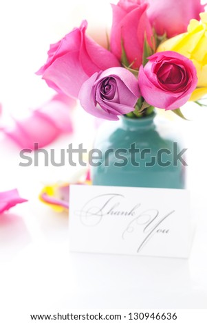 bouquet of colorful roses in vase,petals and card with the words thank you