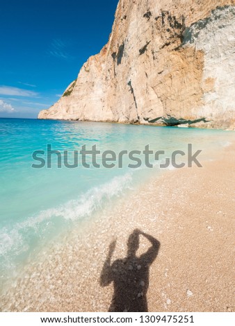 Shadow of a man in the sand at Navagio Beach, Zakynthos, Greece