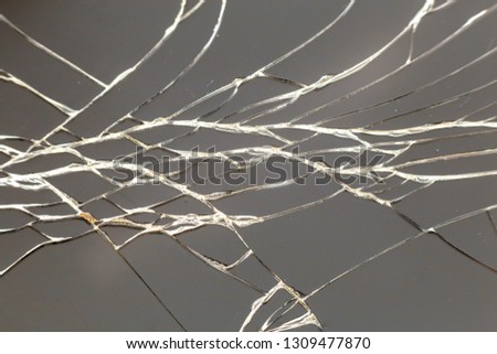 Abstract pattern dark gray background. Crackled screen of mobile cellphone. Gadget repair and maintenance concept.