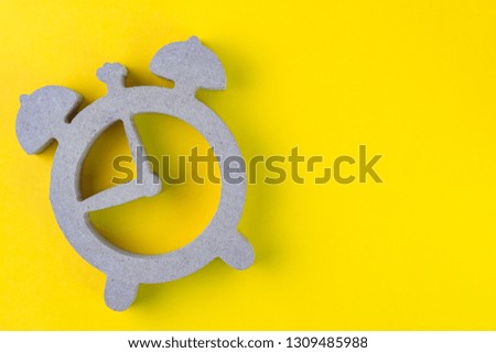 Time, deadline or reminder and schedule concept, wooden alarm clock on yellow background in flat lay or top view, studio shot with copy space.