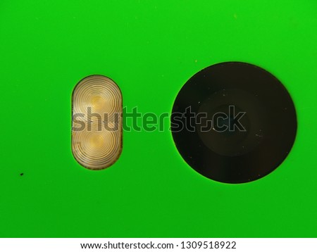 Smartphone camera and flash close Up on green background. Green smartphone camera micro.