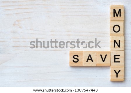 The words "SAVE, MONEY" made with wooden letters isolated on old wood background.