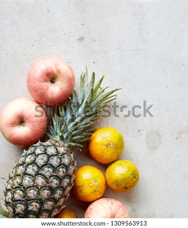 Organic fresh fruits frame on a gray concrete background, clean eating concept. Top view, copy space
