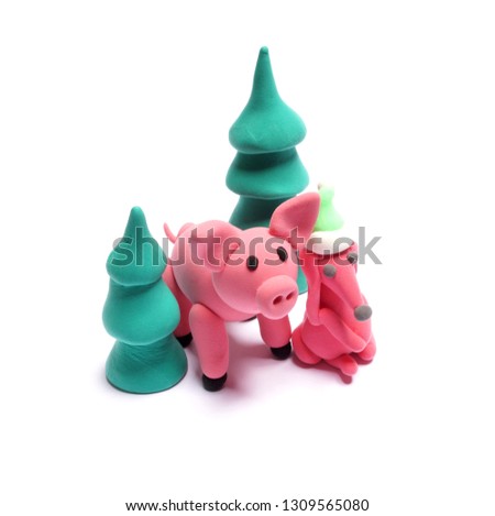 Cute pink pig and red dog of plasticine on a white background