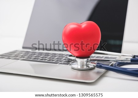 Health stethoscope and red heart on keyboard of laptop computer, medical concept