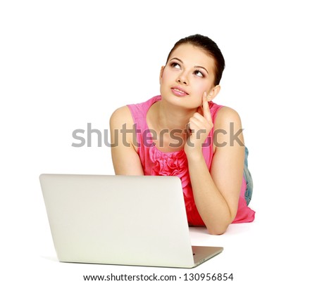 A young woman lying on the floor with a laptop, isolated on white background