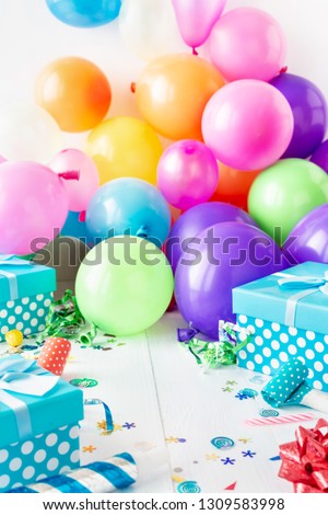 Birthday party background with decoration, balloon, confetti, serpentine, birthday hat and gift boxes on white wooden teble with place for your object