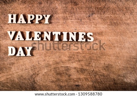 Happy valentine day words in wooden letters on old wooden board 