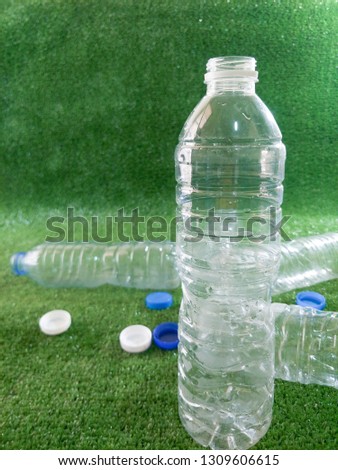 Focus on plastic water bottles, ideas for reuse in order to reduce global warming on artificial grass.