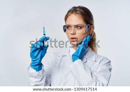   lab technician with glasses looking at a syringe                             