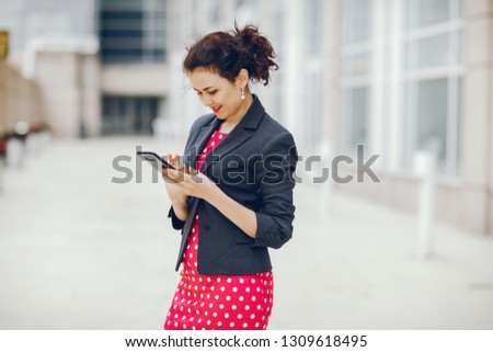 Beautiful businesswoman in a city. Businesswoman in a elegant dress. Lady in a city. Pretty girl with phone. Brunette in a jacket